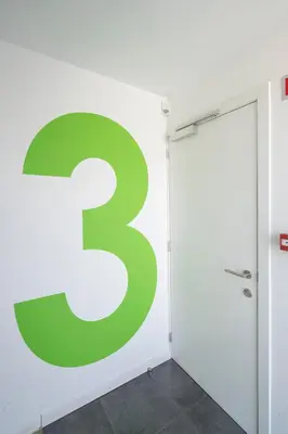 a large green sign on a wall next to a door at SHWAY - The Card Room Green Studio in Antwerp