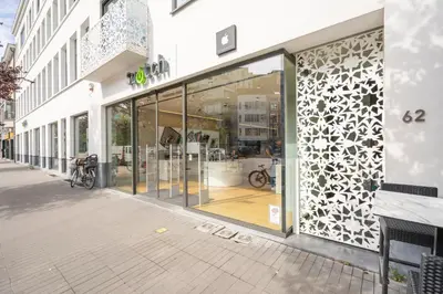 a store front with glass doors on a street at SHWAY - The Card Room Green Studio in Antwerp