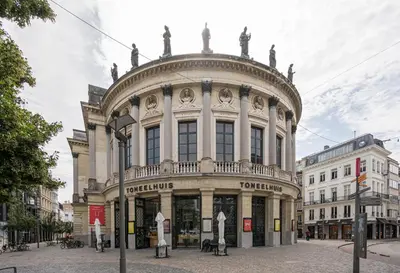 a large building with statues on the top of it at SHWAY - The Card Room Green Studio in Antwerp