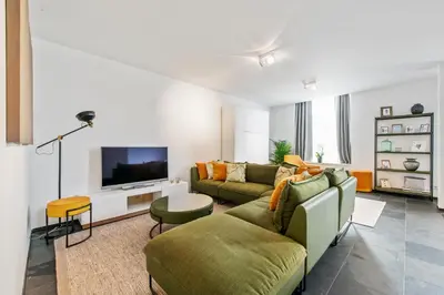 a living room with a couch and a tv at Classy Apartment in City Center with Large Balcony in Ghent