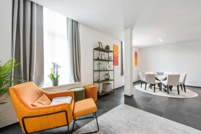 a living room with orange chairs and a table at Classy Apartment in City Center with Large Balcony in Ghent