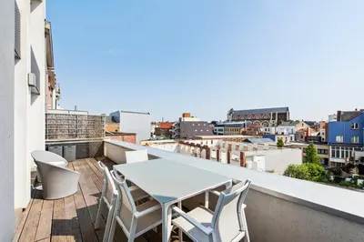 a balcony with a table and chairs on a roof at Classy Apartment in City Center with Large Balcony in Ghent