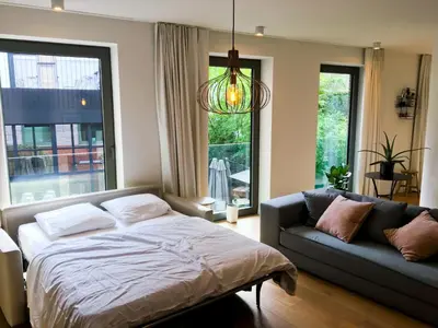 a bedroom with a bed and a couch at Modern Appartment in the Heart of Ghent in Ghent
