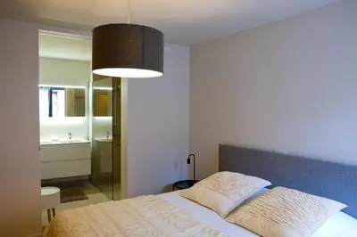 a bedroom with a bed and a large lamp at Modern Appartment in the Heart of Ghent in Ghent