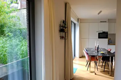 a kitchen and dining room with a table and a window at Modern Appartment in the Heart of Ghent in Ghent