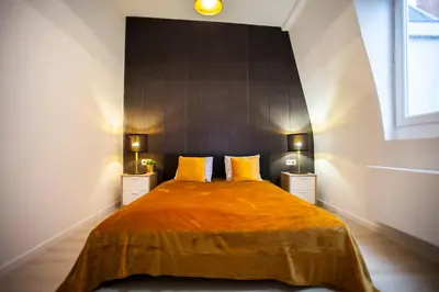 a bedroom with a large bed with yellow pillows at Luxury Suites Grotemarkt by Rikas Hotels in Antwerp