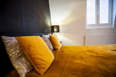 a bedroom with a bed with yellow sheets and a window at Luxury Suites Grotemarkt by Rikas Hotels in Antwerp