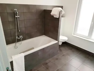 a bathroom with a bath tub and a toilet at City Brussels Apartments in Brussels