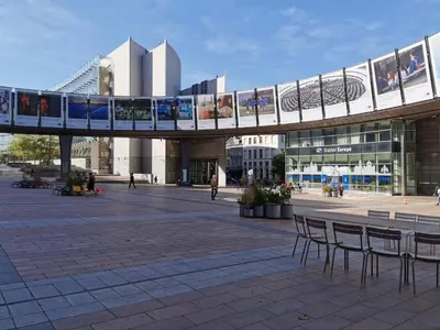 a bridge over a plaza with chairs and a building at Cosy Europarlament apartment in Brussels