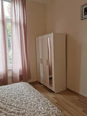 a bedroom with a wardrobe and a bed and a window at Cosy Europarlament apartment in Brussels