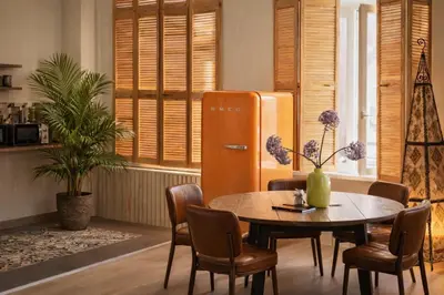 a dining room with a table and a refrigerator at SLEEP INN - 1001 Nights Loft Citycenter with Balconyview in Antwerp