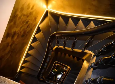 a gold stair case with a mirror on it at SLEEP INN - 1001 Nights Loft Citycenter with Balconyview in Antwerp