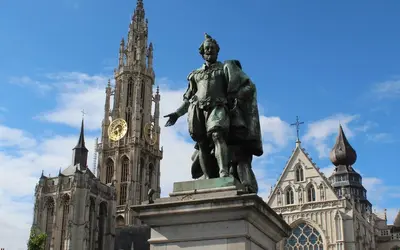 a statue in front of a building with a clock tower at SLEEP INN - 1001 Nights Loft Citycenter with Balconyview in Antwerp