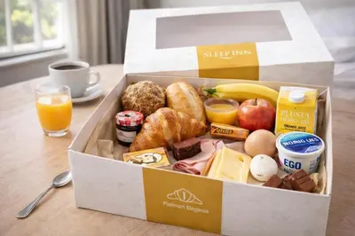 a box of breakfast food on a table with orange juice at SLEEP INN - 1001 Nights Loft Citycenter with Balconyview in Antwerp