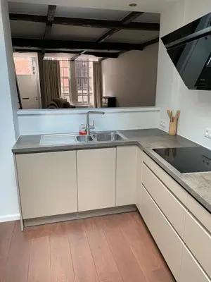 a kitchen with white cabinets and a sink and a mirror at Entire House In Centre of Ghent in Ghent