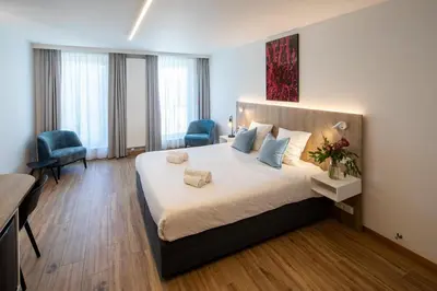a bedroom with a large bed and a desk and chairs at Hotel Den Briel in Ghent