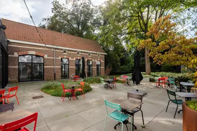a patio with tables and chairs in front of a building at Hotel Den Briel in Ghent