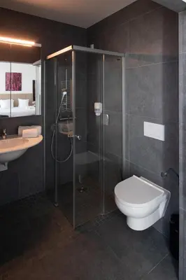 a bathroom with a shower and a toilet and a sink at Hotel Den Briel in Ghent