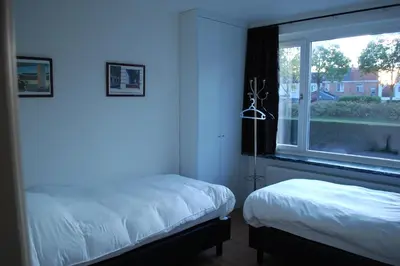 a bedroom with two beds and a window at Hoppernachten in Zele