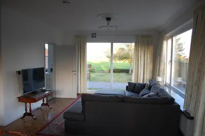 a living room with a couch and a television at Hoppernachten in Zele