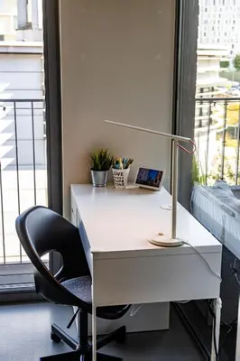 a white desk with a chair and a lamp at London 993 Apt 202 in Antwerp