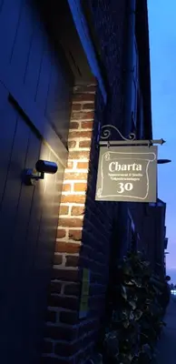 a sign on the side of a building with a brick wall at Charta Appartement in Kortenberg