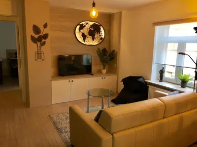 a living room with a couch and a tv at Charta Appartement in Kortenberg