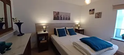 a bedroom with a large bed with blue pillows at Charta Appartement in Kortenberg