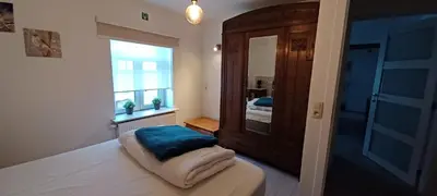 a bedroom with a bed with a mirror and a window at Charta Appartement in Kortenberg