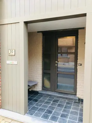a door of a house with a bench next to it at Charta Appartement in Kortenberg