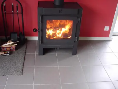 a stove in a room with a fire in it at Kromven in Merksplas