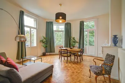 a living room with a table and chairs at Theodore Residence in the Heart of Antwerp in Antwerp