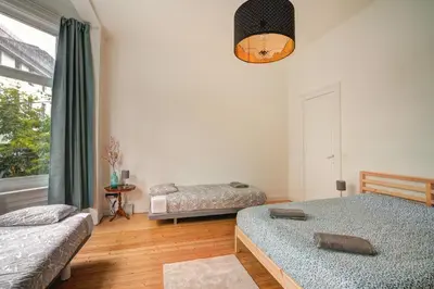 a bedroom with two beds and a window at Theodore Residence in the Heart of Antwerp in Antwerp