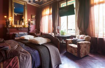 a bedroom with a bed and a chair and a mirror at B&B De Lachende Engel in Mechelen