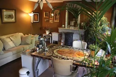 a living room with a table and a couch at B&B De Lachende Engel in Mechelen
