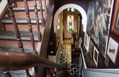 a hallway with stairs and stained glass windows at B&B De Lachende Engel in Mechelen