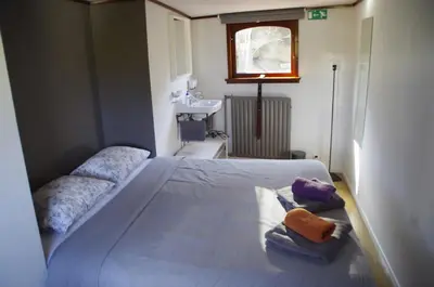 a bedroom with a bed with two towels on it at B&B B³ Boat in Ghent