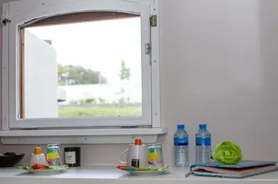 a window above a kitchen counter with bottles of water at B&B B³ Boat in Ghent