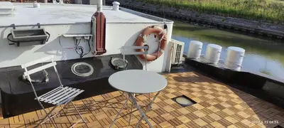 a table and chair on a boat in the water at B&B B³ Boat in Ghent