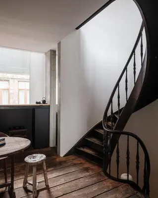a spiral staircase in a room with a table at Shelter 7 in Ghent
