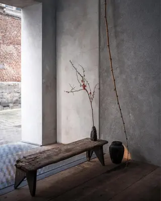 a wooden bench with a vase and a plant in a room at Shelter 7 in Ghent