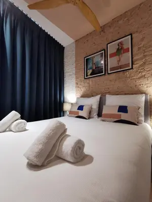 a bedroom with a large white bed with towels on it at SHWAY - The Pink Pigeon in Antwerp