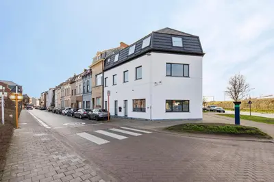 a white building with a black roof on a street at Design Loft near the city of Ghent in Ghent
