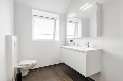 a white bathroom with a toilet and a sink at Design Loft near the city of Ghent in Ghent