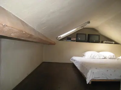 an attic bedroom with a bed and a light at Vakantiehuis in de velden met zwemvijver en Jeu de Boules baan in Lier