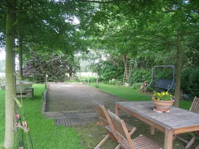 a picnic table with a pot of flowers on it at Vakantiehuis in de velden met zwemvijver en Jeu de Boules baan in Lier