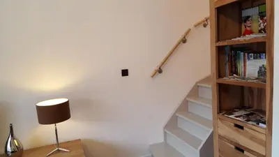 a staircase with a book shelf and a lamp at Huis van Vletingen Apartment in Ghent