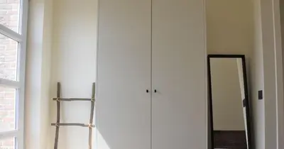 a white closet with a mirror next to a window at Vakantiewoning Lescaut in Hamme
