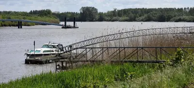 a boat is docked at a dock on a lake at Vakantiewoning Lescaut in Hamme