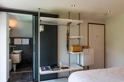 a bedroom with a bed and a bathroom with a sink at B&B Hier en Nu in Heusden